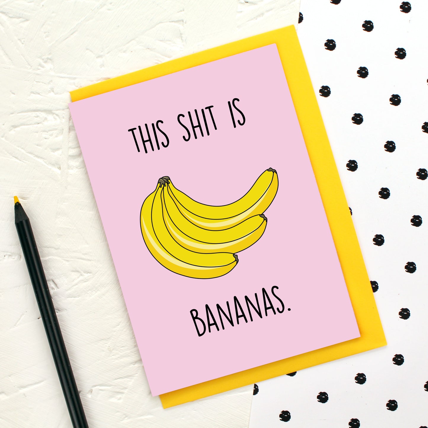 A bunch of bananas on a pink background and the words 'This Shit is Bananas'