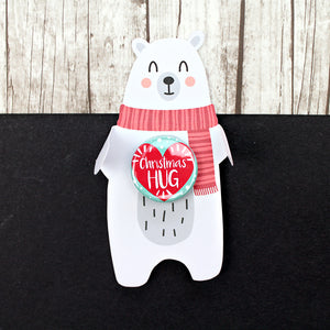 White polar bear in a red scarf with a Christmas hug badge