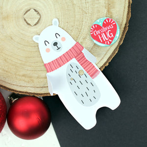 Polar bear with rosy cheeks and a red scarf and a Christmas hug badge