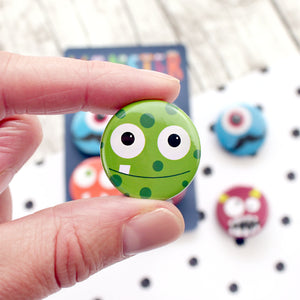 An adorable green spotty monster with one tooth