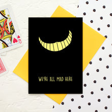 Load image into Gallery viewer, Alice in Wonderland themed Card with a yellow Cheshire Cat smile and the words &#39;We&#39;re All Mad Here&#39;